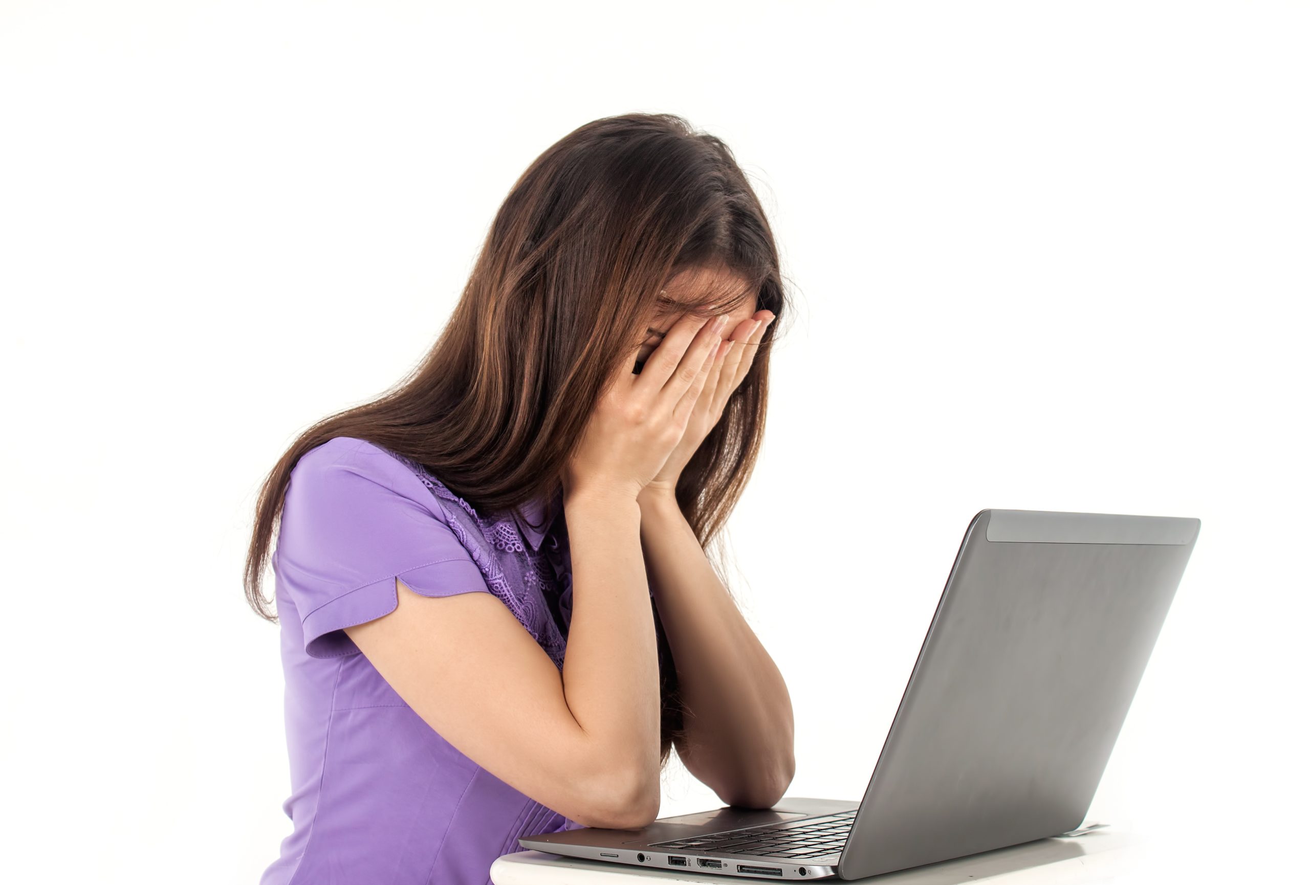 パソコンの画面を見て泣いている女性